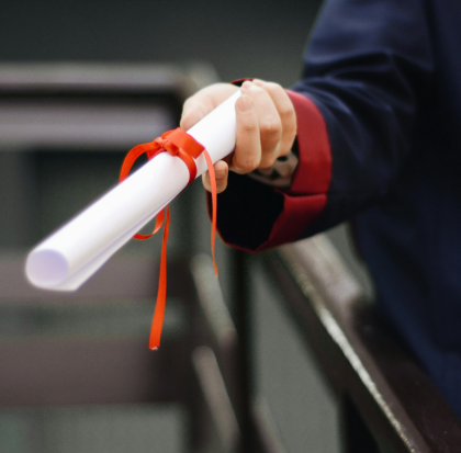 A graduate holding a degree scroll