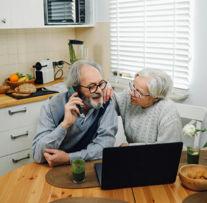 An elderly couple sitting by the table and having a conversation