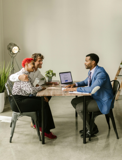 A financial advisor talking to a couple at a desk